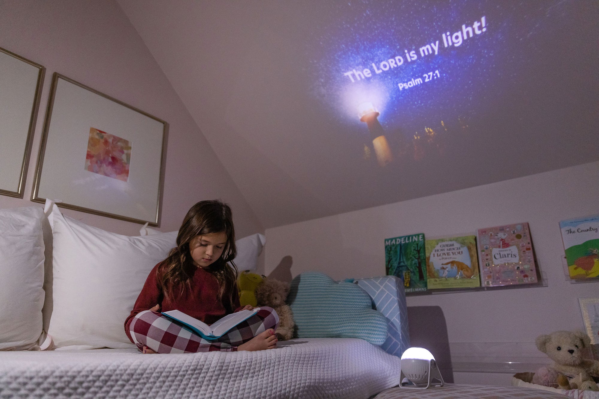 Young girl reading as projector shows bible verses on ceiling