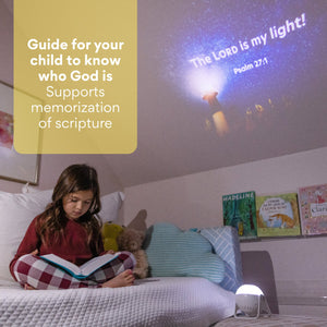 Young girl sitting on bed reading the bible with Glorilight on and shining the Bible verse Psalm 27.1 "The Lord is my Light!" Text reads as Guide for your child to know who God is. Supports memorization of scripture. 